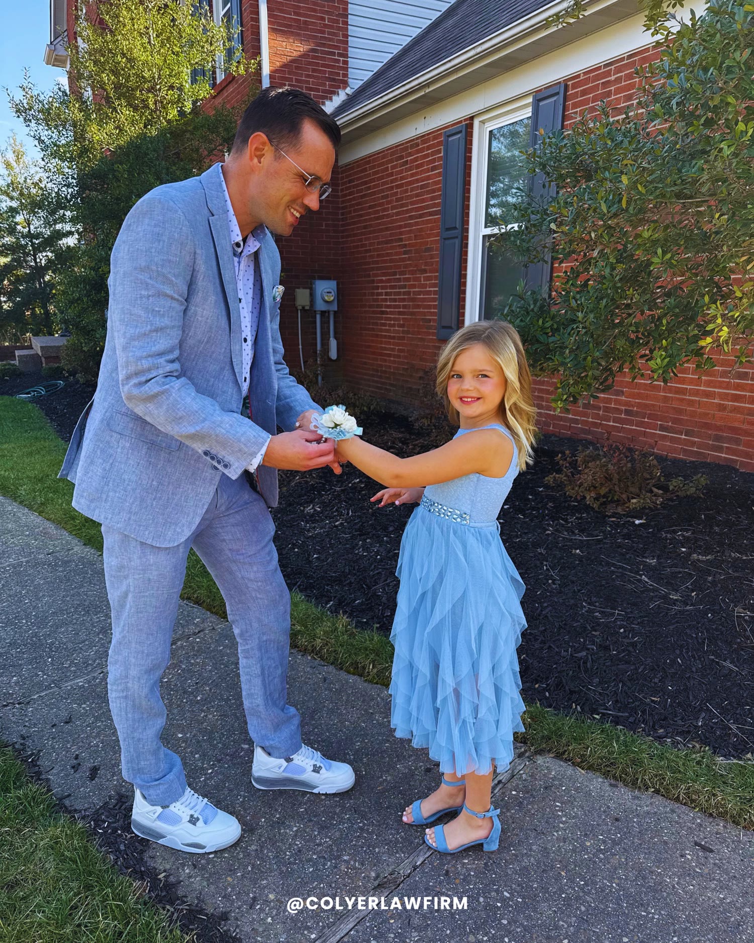 Tony Colyer pinning a corsage on his daughter before a daddy-daughter dance.